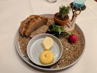 Kleiner hausgebackener Laib Brot mit:  Aufstrich | Salzbutter | Kresse | Fleur de sel | Zitronenpfeffer | Radieschen